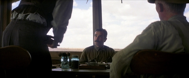 Frame from There Will Be Blood — sitting, table, shirt