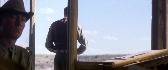 Wide shot frame from There Will Be Blood — standing, hat, shirt
