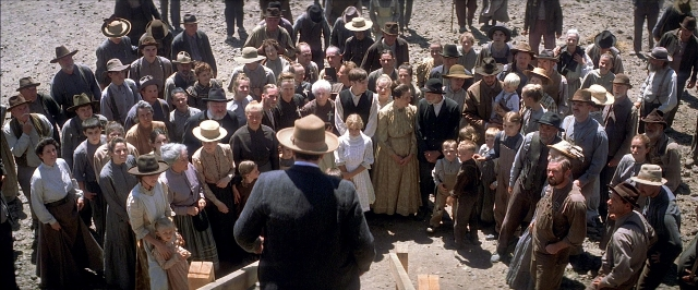 Wide shot frame from There Will Be Blood — standing, walking, hat