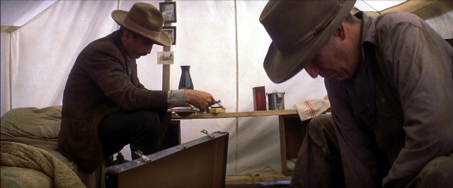 Wide shot frame from There Will Be Blood — sitting, book, table