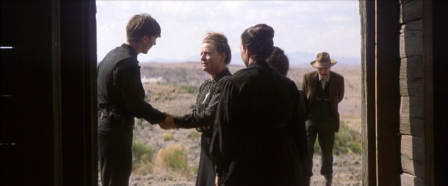 Frame from There Will Be Blood — standing, door, hat