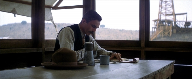 Wide shot frame from There Will Be Blood — sitting, room, table