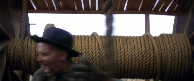 Wide shot frame from There Will Be Blood — standing, hat, face