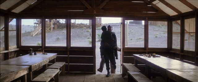 Wide shot frame from There Will Be Blood — walking, room, table
