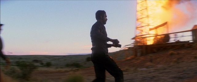 Wide shot frame from There Will Be Blood — walking, street, fire