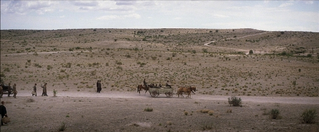 Frame from There Will Be Blood — sitting, walking, horse