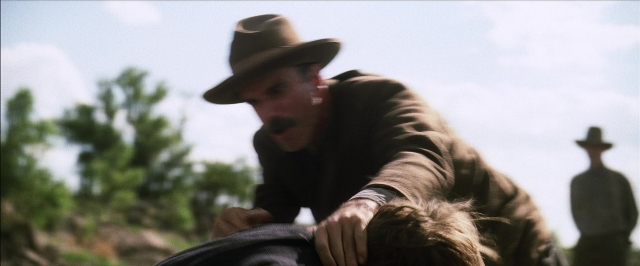 Wide shot frame from There Will Be Blood — hat, mustache, face