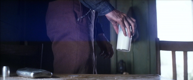 Wide shot frame from There Will Be Blood — standing, room, table