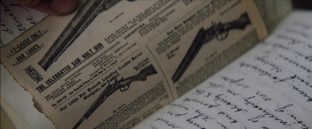 Frame from There Will Be Blood — book, gun, newspaper