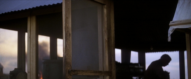 Wide shot frame from There Will Be Blood — standing, door, house