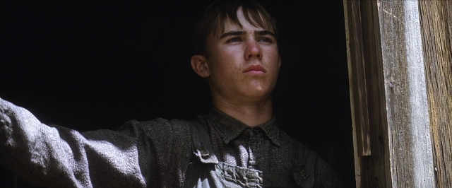 Medium shot frame from There Will Be Blood — standing, door, shirt
