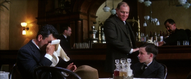 Wide shot frame from There Will Be Blood — sitting, standing, room