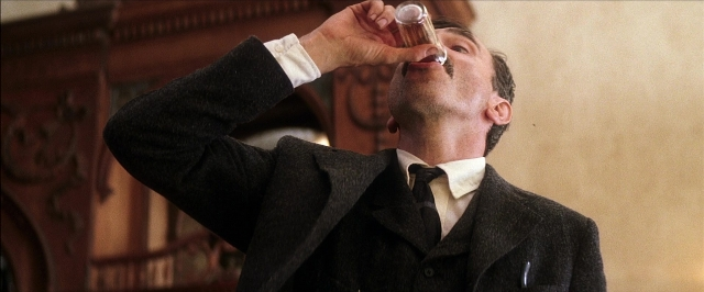 Wide shot frame from There Will Be Blood — standing, room, hand