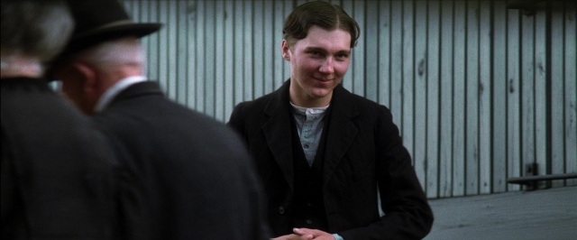 Wide shot frame from There Will Be Blood — standing, room, hat