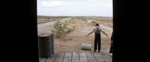 Wide shot frame from There Will Be Blood — standing, shirt, train