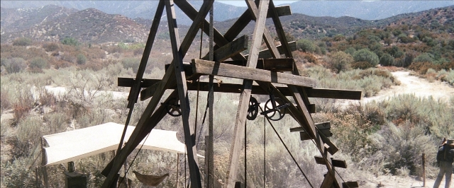 Wide shot frame from There Will Be Blood — standing, wheel, person
