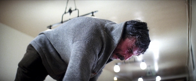 Wide shot frame from There Will Be Blood — room, hand, hair