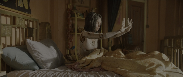 Wide shot frame from Alita: Battle Angel — sitting, room, bed