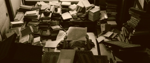 Medium shot frame from Kyôfu kikei ningen: Edogawa Rampo zenshû — sitting, book, room