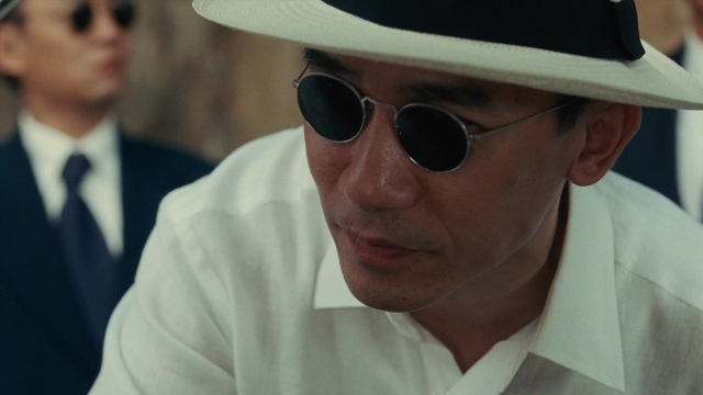 Wide shot frame from Se, jie — hat, suit, shirt
