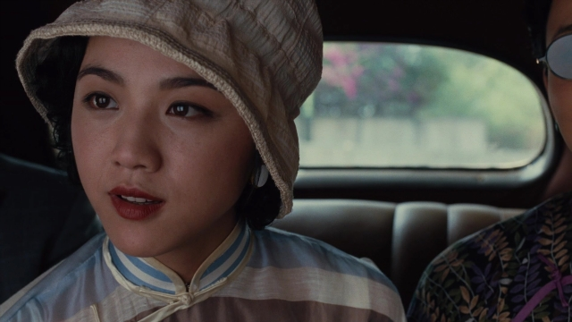 Close-up frame from Se, jie — sitting, hat, car