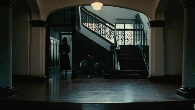 Wide shot frame from Se, jie — standing, room, bicycle
