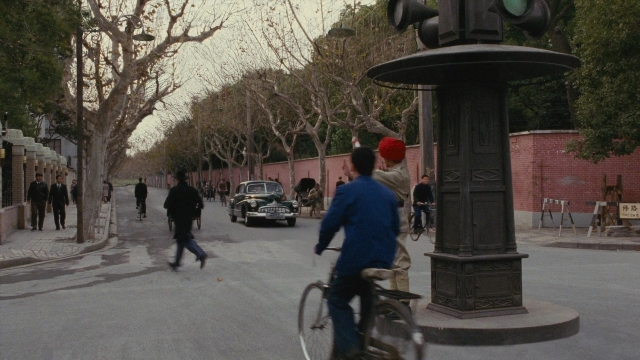 Wide shot frame from Se, jie — walking, street, car