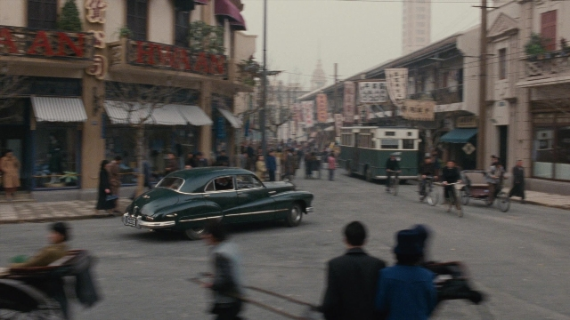 Wide shot frame from Se, jie — walking, street, car