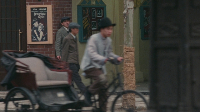 Wide shot frame from Se, jie — walking, street, hat