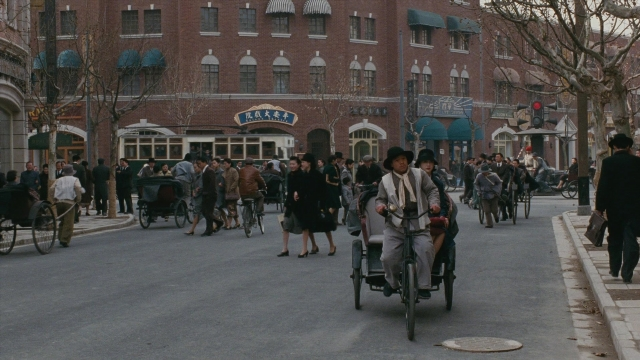 Wide shot frame from Se, jie — walking, street, bicycle