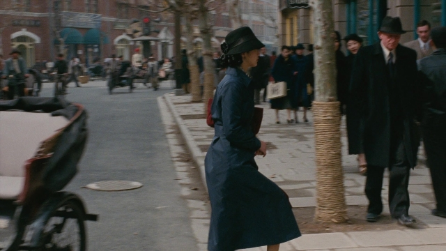 Wide shot frame from Se, jie — walking, street, hat