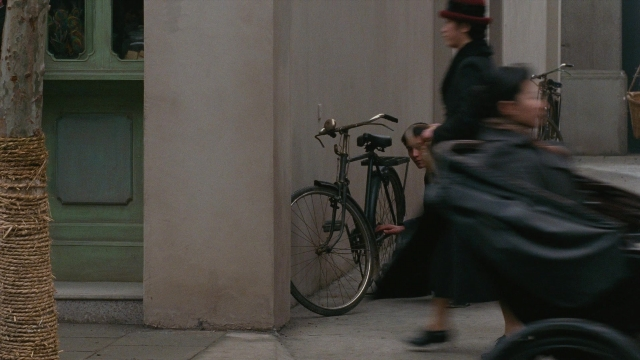 Wide shot frame from Se, jie — walking, door, street
