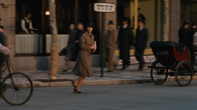 Wide shot frame from Se, jie — walking, street, hat