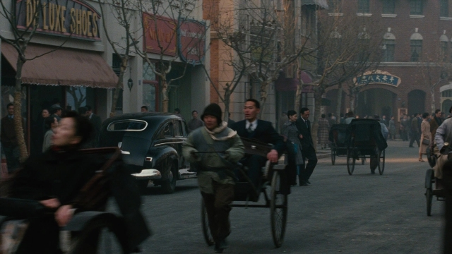 Wide shot frame from Se, jie — walking, street, car