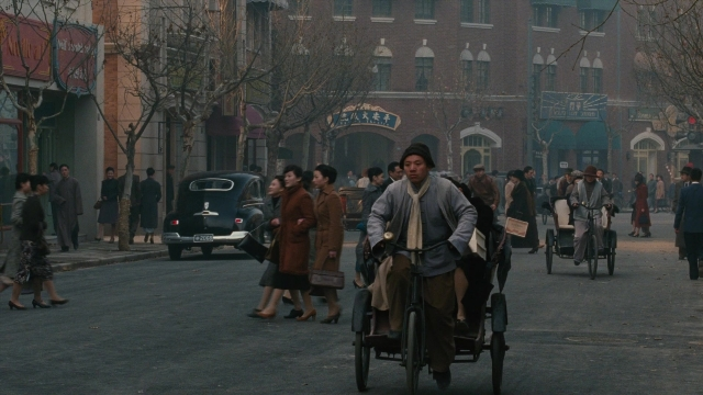 Wide shot frame from Se, jie — walking, street, hat