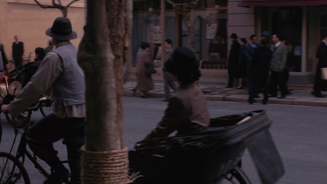 Wide shot frame from Se, jie — sitting, walking, street