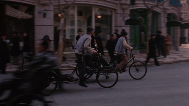 Wide shot frame from Se, jie — walking, street, hat