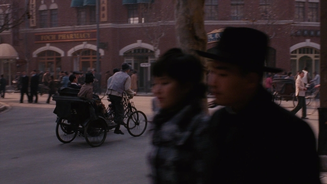 Wide shot frame from Se, jie — walking, street, hat