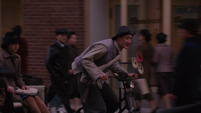 Wide shot frame from Se, jie — sitting, walking, street