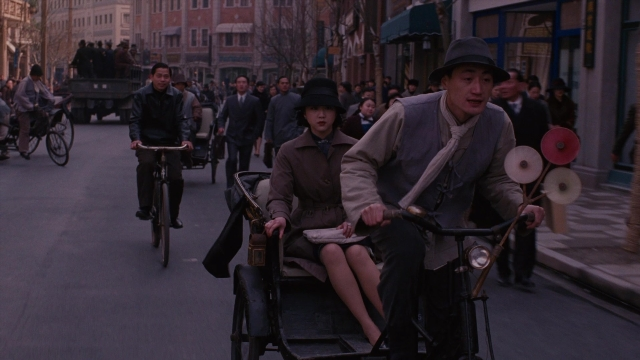 Wide shot frame from Se, jie — sitting, walking, street