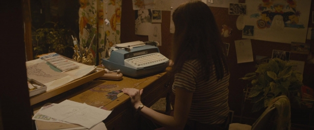 Wide shot frame from The Diary of a Teenage Girl — sitting, shirt, office