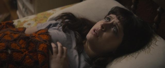 Frame from The Diary of a Teenage Girl — bed, hand, dress