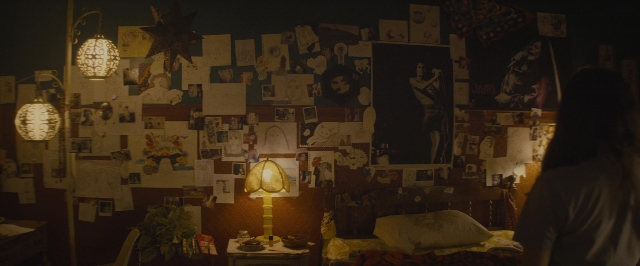 Wide shot frame from The Diary of a Teenage Girl — standing, room, table