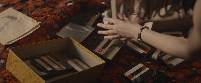 Wide shot frame from The Diary of a Teenage Girl — room, bed, hand