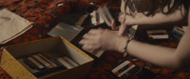 Frame from The Diary of a Teenage Girl — sitting, bed, box