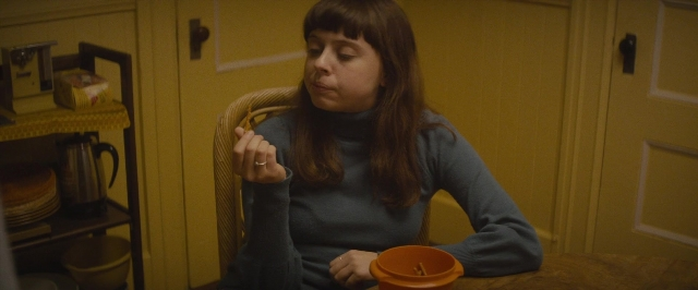 Frame from The Diary of a Teenage Girl — sitting, kitchen, hand