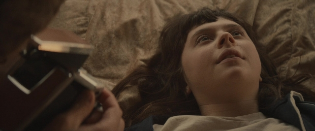 Wide shot frame from The Diary of a Teenage Girl — room, bed, hand