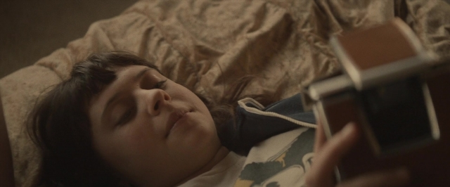Frame from The Diary of a Teenage Girl — bed, phone, hand