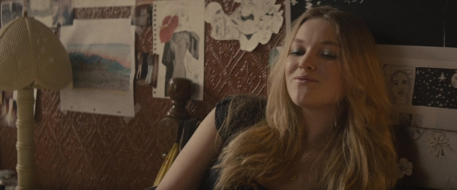 Medium shot frame from The Diary of a Teenage Girl — sitting, room, dress