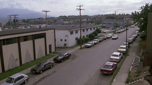 Frame from The Accused — street, car, house